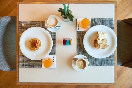 a table with plates of food and cups of coffee at UNAHOTELS Varese in Varese
