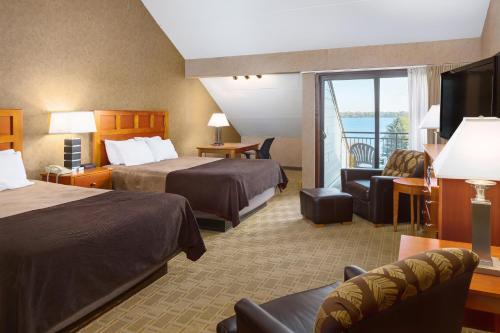 a hotel room with two beds and a balcony at Arrowwood Resort Hotel and Conference Center - Alexandria in Alexandria