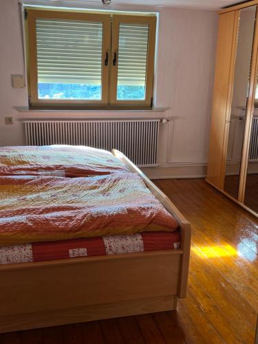 1 dormitorio con 1 cama y ventana con persianas en Gemütliche Wohnung im Herzen vom Dorf en Mudersbach