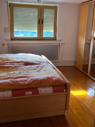 a bedroom with a bed and a window with blinds at Gemütliche Wohnung im Herzen vom Dorf in Mudersbach