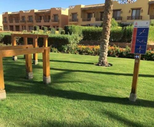 a park with a bench and a palm tree and a building at Luxury Chalet in Mountain View 2 , El-Sokhna with Sea View , Pool View and Garden View Families Only in Ain Sokhna