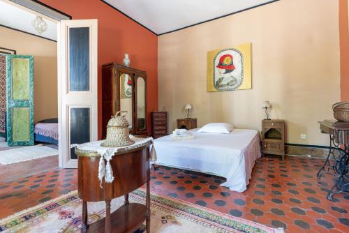 Schlafzimmer mit einem weißen Bett und orangefarbenen Wänden in der Unterkunft Maison Avec Piscine, Tennis, Sauna in Marsillargues
