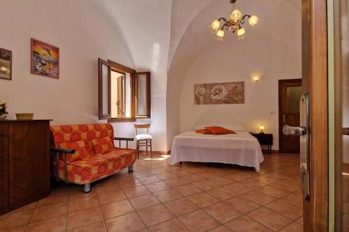 een slaapkamer met een bed en een stoel in een kamer bij Comodissima casa per vacanza in Parabita