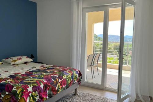 une chambre avec un lit et une porte coulissante en verre dans l'établissement Appartement neuf dans maison, à Taradeau