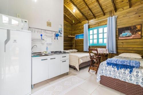 cocina con 2 camas y lavabo en una habitación en Jajá Cabanas, en Palhoça