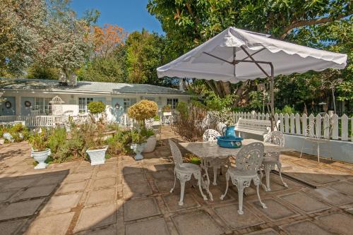 a patio with a table and chairs and an umbrella at The Lady Grace in Greyton