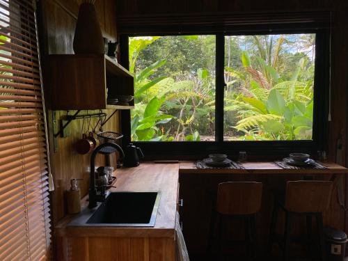 a kitchen with a sink and a large window at Kabinji Bali in Tampaksiring