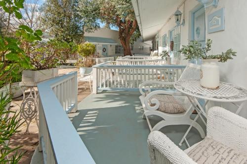 a patio with chairs and a table with a vase on it at The Lady Grace in Greyton