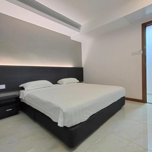a bedroom with a large bed with white sheets at Comfort Inn Salim in Sibu