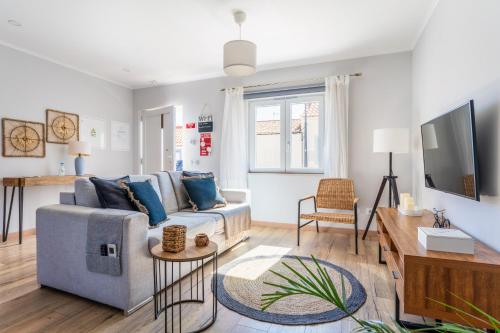 a living room with a couch and a tv at Windmill Escape - Areia Townhouse by Lisbeyond in Odeceixe