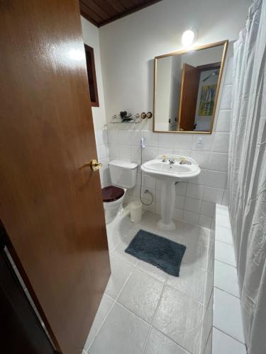 uma casa de banho com um lavatório, um WC e um espelho. em Chalés da montanha em Itaipava