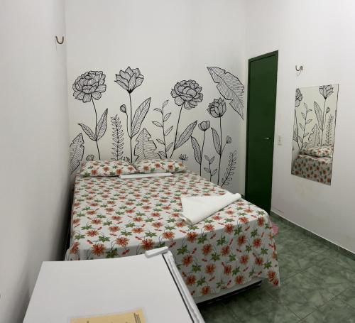 a bedroom with a bed with flowers on the wall at Suíte central Pousada in Jijoca de Jericoacoara