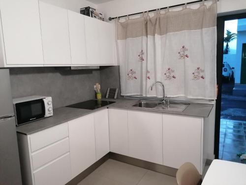 a kitchen with white cabinets and a sink and a window at Vivienda El Remo-Vv-3 in Los Llanos de Aridane