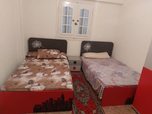 Cette chambre comprend 2 lits et une fenêtre. dans l'établissement فيلا انور يسن ابو كليلة, à Zāwiyat al Habbābīyah