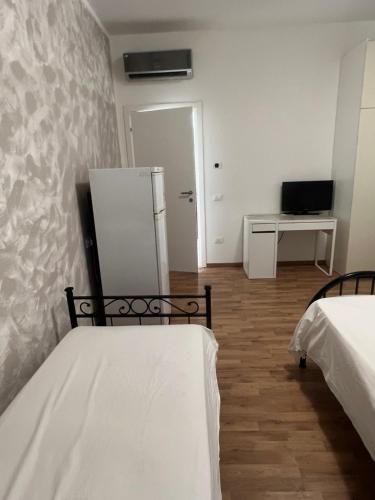 um quarto com 2 camas e um frigorífico em B&B Treviso em Treviso