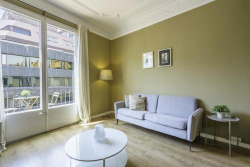 uma sala de estar com um sofá e uma grande janela em Ola Living Aribau Apartments em Barcelona
