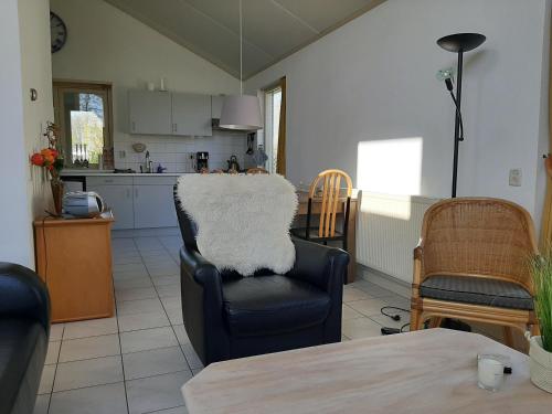 a living room with a chair and a kitchen at Huisje Earrebarre in Tzummarum