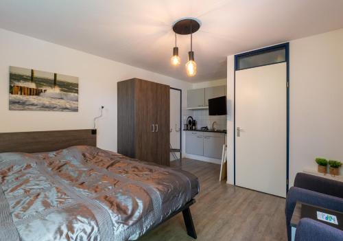 Un dormitorio con una cama y una cocina. en Studio Oase Zoutelande, en Zoutelande