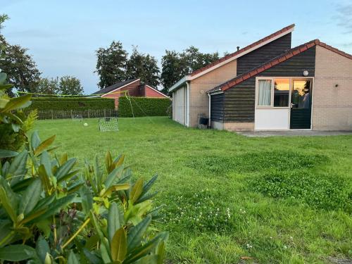 a house with a grassy yard with a house at Huisje Earrebarre in Tzummarum
