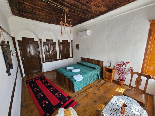 Schlafzimmer mit einem grünen Bett und Holzböden in der Unterkunft Guest House Panorama in Berat