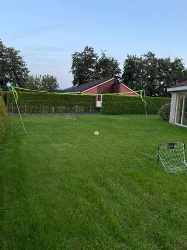 a yard with a net in the grass at Huisje Earrebarre in Tzummarum