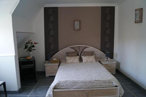 a bedroom with a large bed and two night stands at Le Relais De Dalibray in Seraincourt