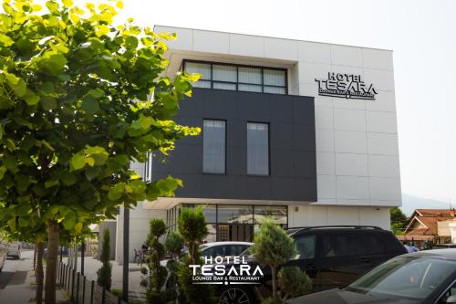 a hotel tesara building with cars parked in front at Hotel Tesara in Prizren