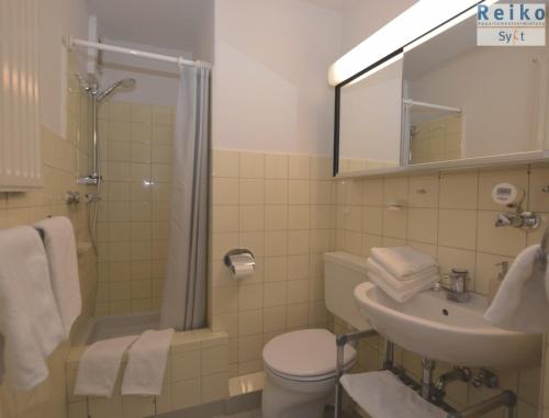 ein Bad mit einem Waschbecken, einem WC und einer Dusche in der Unterkunft Strand-Gut, 12-29 in Westerland