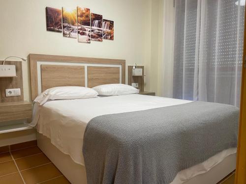 um quarto com uma grande cama branca e uma janela em Apartamento Natur Spa em Villanueva de Río Segura