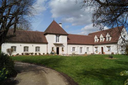 a large white building with a brown roof at Le Relais De Dalibray in Seraincourt