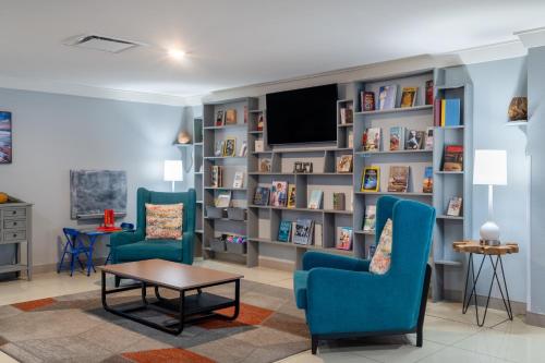a living room with two chairs and a tv at TRYP by Wyndham Tallahassee North I-10 Capital Circle in Tallahassee