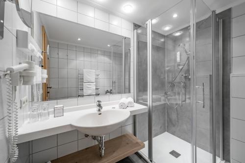 a bathroom with a sink and a shower at Hotel Tyrolerhof in Sölden