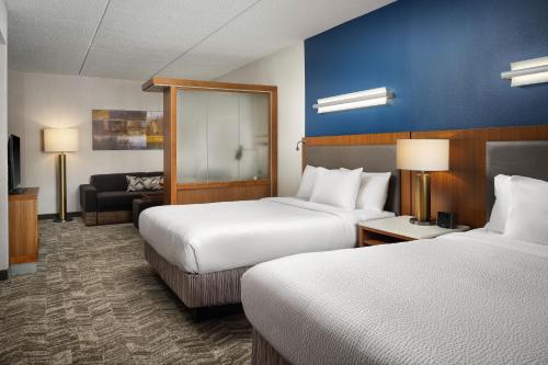 a hotel room with two beds and a couch at SpringHill Suites by Marriott Pittsburgh Mt. Lebanon in Mount Lebanon
