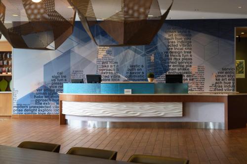 a waiting room with a blue counter and a wall with words at SpringHill Suites by Marriott Pittsburgh Mt. Lebanon in Mount Lebanon