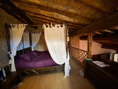 a bedroom with a bed with curtains in a attic at La Cabaña 