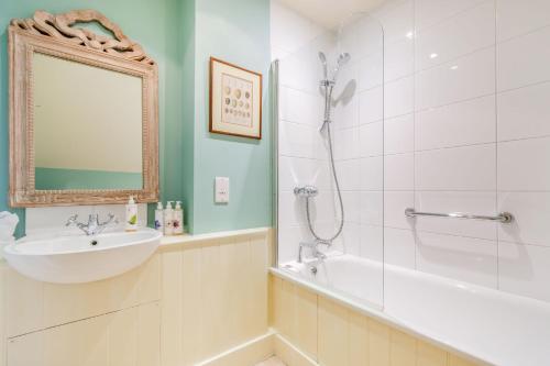 een badkamer met een bad, een wastafel en een douche bij Tiger Inn - Elizabeth in Eastbourne