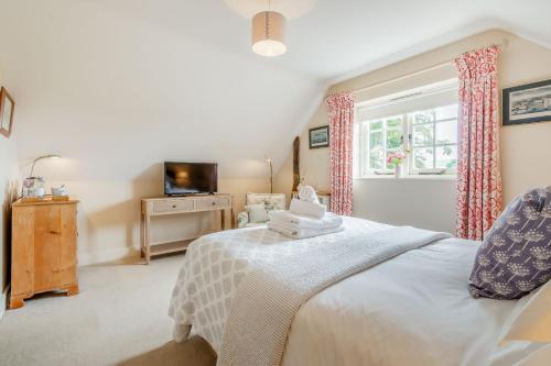 um quarto com uma cama, uma televisão e uma janela em Tiger Inn - Elizabeth em Eastbourne