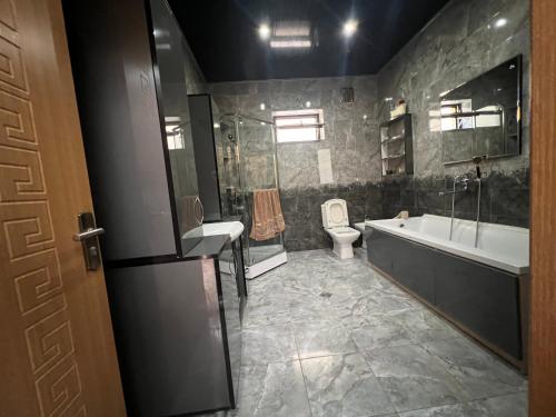 ein Badezimmer mit einer Badewanne, einem Waschbecken und einem WC in der Unterkunft Ivertubani House in Tbilisi City