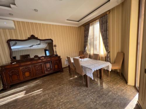 ein Esszimmer mit einem Tisch und einem Spiegel in der Unterkunft Ivertubani House in Tbilisi City