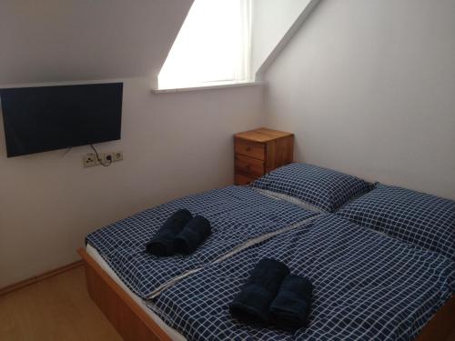 a bedroom with a bed with two black pillows on it at Diana Lak III. in Tököl