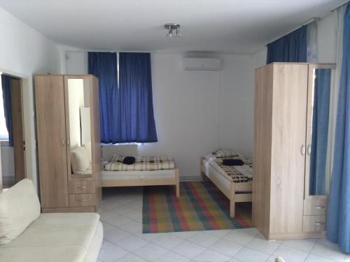 a small room with two beds and blue curtains at Diana Lak III. in Tököl