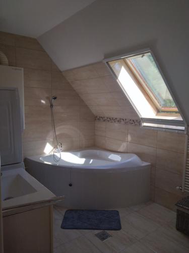 a large bath tub in a bathroom with a window at Diana Lak III. in Tököl