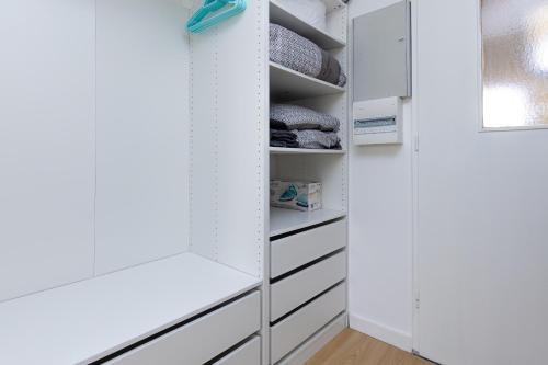 a closet with white cabinets and drawers at Le Balcon du Port - Joli studio à Capbreton in Capbreton