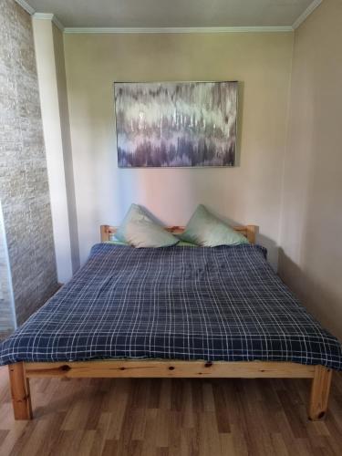 a bed in a room with a blue plaid mattress at Apartments - Alauksta in Rīga