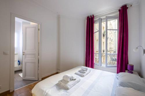 une chambre avec un lit blanc avec des serviettes dessus dans l'établissement Goujon - Cozy apartment in Nation-Picpus neighborhood, à Paris