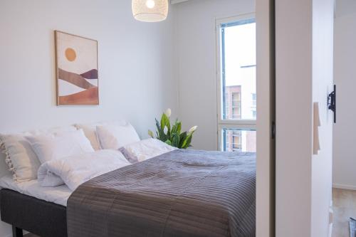 a bedroom with a bed with white walls and a window at Snowflake Suites I in Rovaniemi