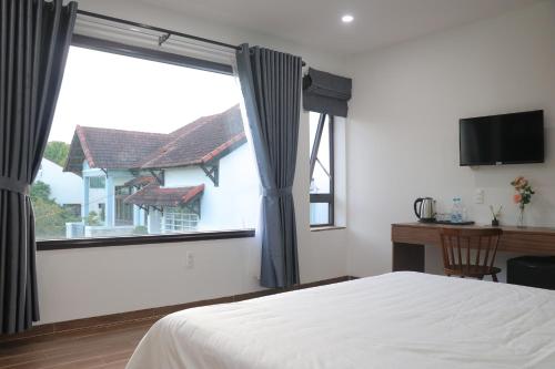 a bedroom with a bed and a large window at Là Nhà Homestay Huế in Thôn Dương Xuân Hạ