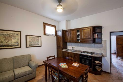 ein Wohnzimmer mit einem Tisch und einem Sofa sowie eine Küche in der Unterkunft Appartamenti immersi nelle colline Toscane in Molino Mazzetti