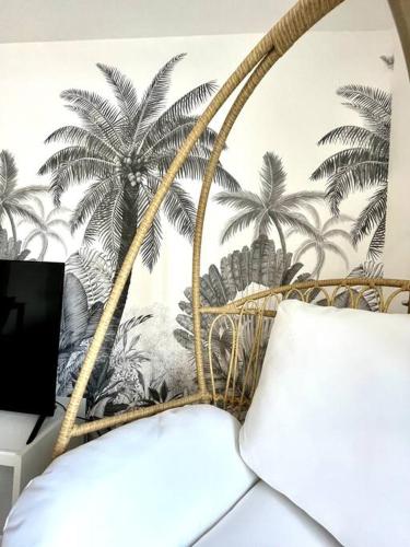 une chambre avec une fresque murale de palmiers sur le mur dans l'établissement L'Instant Présent - Calme & Élégant proche gare, à Roanne