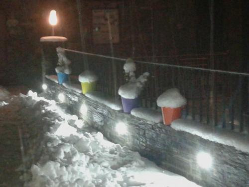 a fence covered in snow with buckets and lights at Apartaments Fontalba in Queralbs